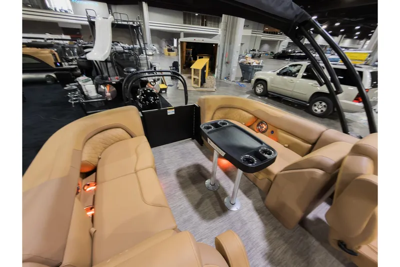 Slide: The Image of Interior of 2026 Godfrey Sweetwater 22' Tritoon with tan seating and table. - 16