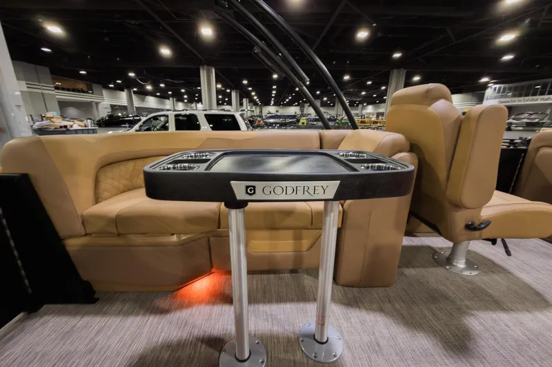 Slide: The Image of Luxurious interior of 2026 Godfrey Sweetwater 22' Split Bench Tritoon, featuring plush seating and table. - 17