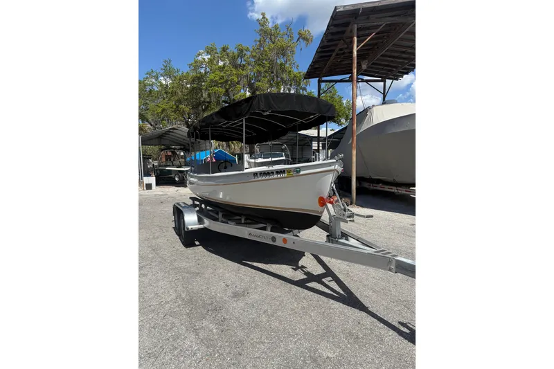 The Image of 2004 Duffy 18 electric boat on trailer, parked outdoors under clear sky. - 1