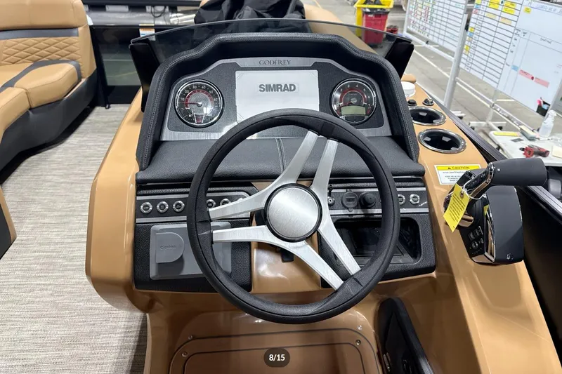 Slide: The Image of 2026 Godfrey Monaco 23' Tritoon dashboard with steering wheel and controls. - 10