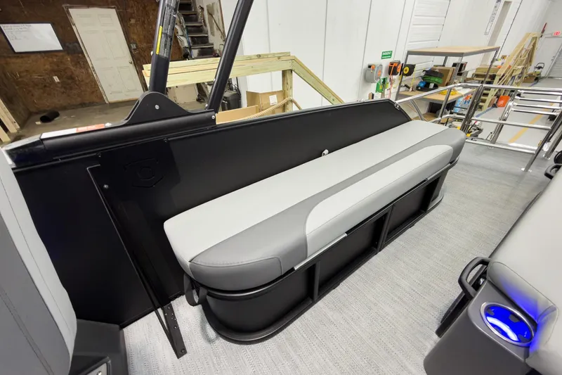 Slide: The Image of 2026 Godfrey Monaco 23' Tritoon with single flip lounge seating in a workshop setting. - 33