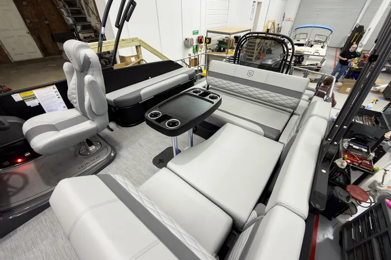 Slide: The Image of 2026 Godfrey Monaco 23' Tritoon interior with luxurious seating and table setup. - 34