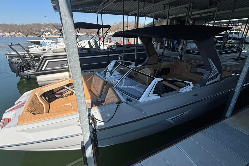 The Image of 2026 Tigé 24RZX boat docked in a marina, featuring sleek design and luxurious seating. - 0