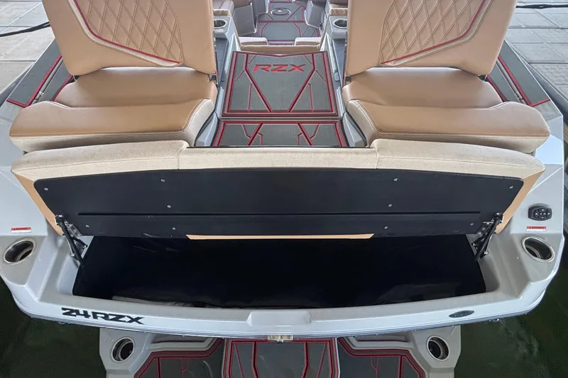 Slide: The Image of 2026 Tigé 24RZX boat interior with tan seats and open storage compartment. - 13