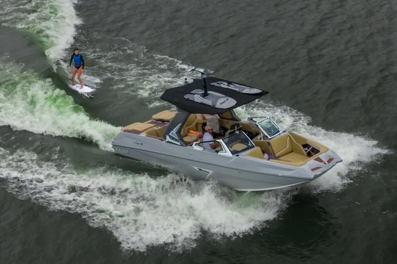 The Image of 2026 Tigé 24RZX boat creating waves for a wakeboarder on a lake. - 0