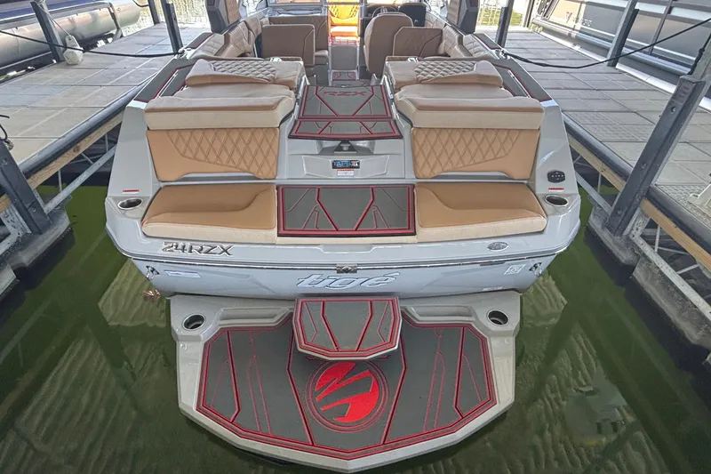 Slide: The Image of 2026 Tigé 24RZX boat with tan seating and red-accented flooring in a dock. - 4