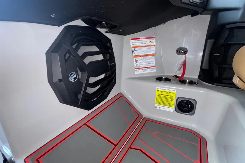 Slide: The Image of Interior of 2026 Tigé 24RZX boat featuring speaker, cup holders, and safety labels. - 52
