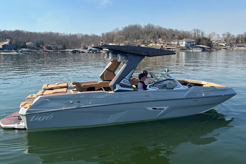 Slide: The Image of 2026 Tigé 24RZX boat on a calm lake with passengers, featuring sleek design and canopy. - 66