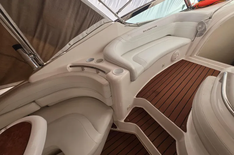 Slide: The Image of 1998 Silverton 361 Express boat interior with white seating and wooden flooring. - 10