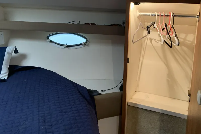 Slide: The Image of Interior of 1998 Silverton 361 Express yacht with bed and open closet. - 16