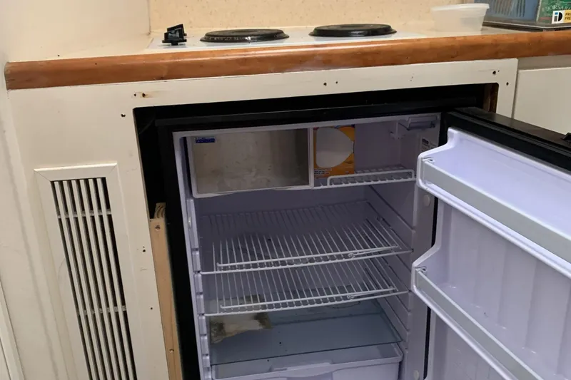 Slide: The Image of 1998 Silverton 361 Express boat kitchen with open fridge and stove. - 21