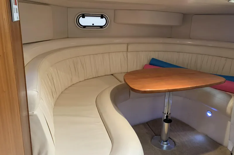 Slide: The Image of 1998 Silverton 361 Express cabin interior with curved seating and wooden table. - 25