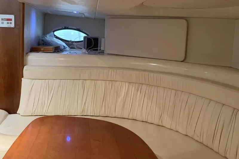 Slide: The Image of Interior of 1998 Silverton 361 Express yacht with curved seating and wooden table. - 26