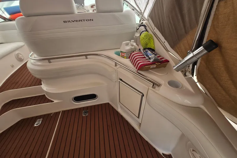 Slide: The Image of 1998 Silverton 361 Express boat interior with white seating and wooden flooring. - 5