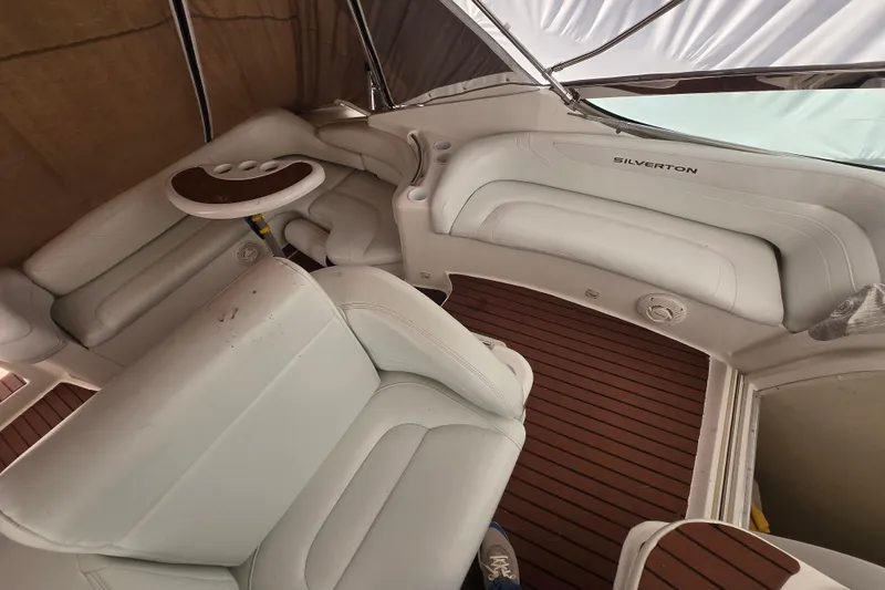 Slide: The Image of Interior of a 1998 Silverton 361 Express boat with white seating and wood flooring. - 7