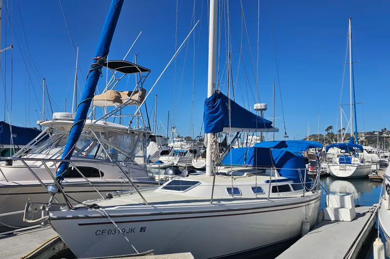 The Image of 1988 Catalina 30 MkII sailboat docked in a marina under clear blue skies. - 0