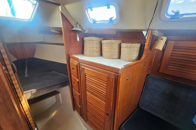 Slide: The Image of Interior of a 1988 Catalina 30 MkII sailboat with wooden cabinetry and wicker baskets. - 17