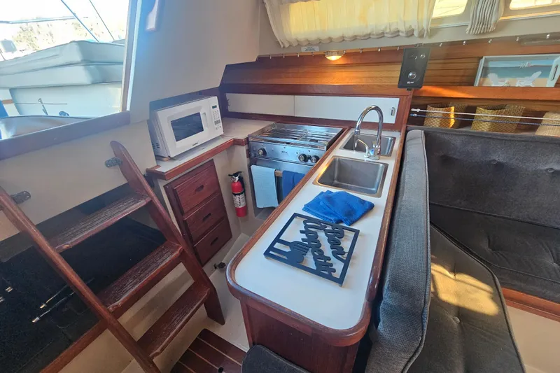 Slide: The Image of Interior of 1988 Catalina 30 MkII sailboat featuring compact kitchen with stove and microwave. - 20