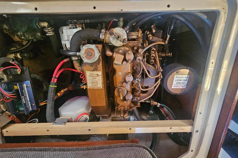Slide: The Image of Engine compartment of a 1988 Catalina 30 MkII sailboat, showcasing mechanical components and wiring. - 24