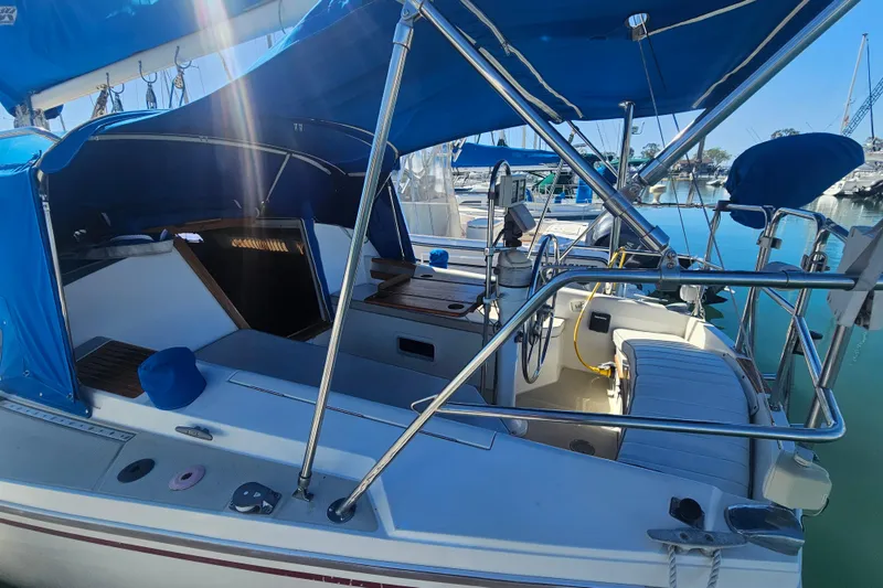 Slide: The Image of 1988 Catalina 30 MkII sailboat with blue canopy, docked in a marina. - 3