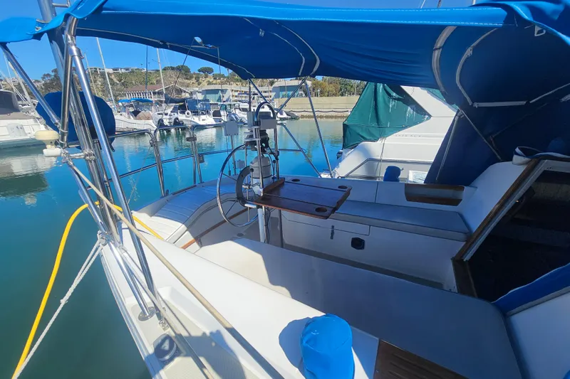 Slide: The Image of 1988 Catalina 30 MkII sailboat cockpit with blue canopy, docked in a marina. - 4