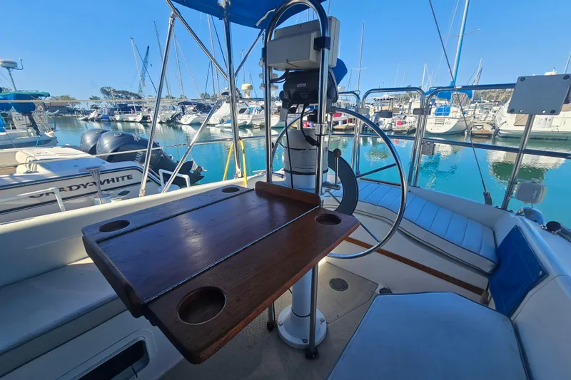 Slide: The Image of Cockpit view of 1988 Catalina 30 MkII sailboat in marina, featuring steering wheel and wooden table. - 6