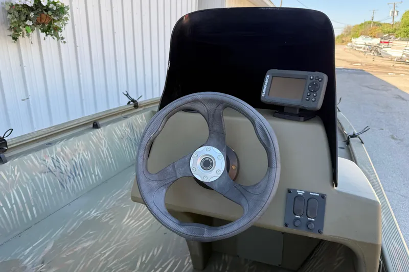 Slide: The Image of 2022 Tracker Grizzly 1648 SC boat console with steering wheel and navigation system. - 14