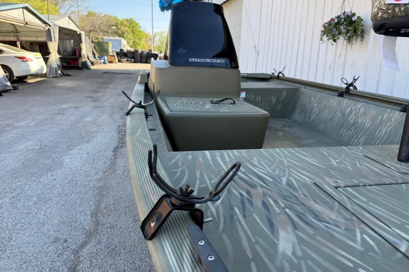 Slide: The Image of 2022 Tracker Grizzly 1648 SC boat with camouflage interior, parked outdoors. - 20