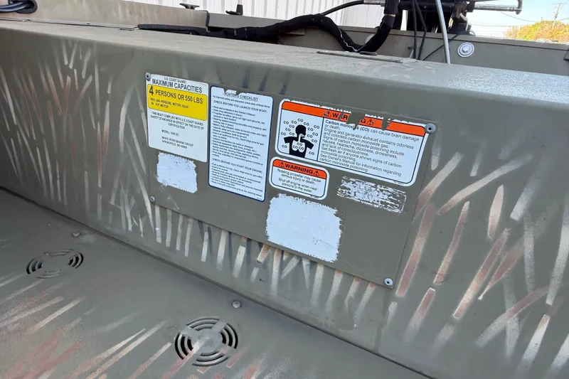 Slide: The Image of 2022 Tracker Grizzly 1648 SC boat with safety and capacity warning labels. - 33