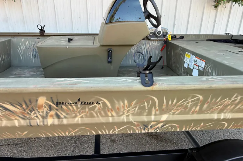 Slide: The Image of 2022 Tracker Grizzly 1648 SC boat with camo design and "Blind Duck" branding. - 34