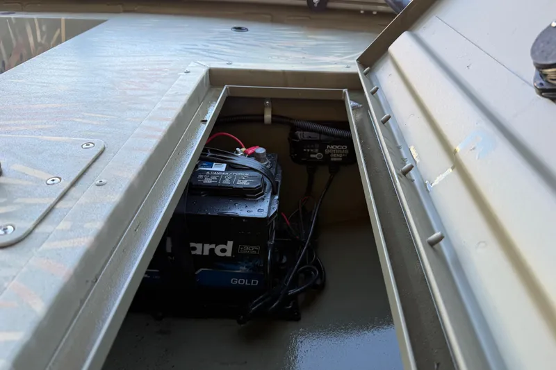 Slide: The Image of 2022 Tracker Grizzly 1648 SC boat battery compartment with Noco Genius charger. - 35
