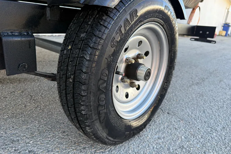 Slide: The Image of Trailer wheel of 2022 Tracker Grizzly 1648 SC on asphalt surface. - 39