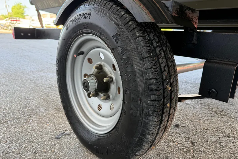 Slide: The Image of Trailer wheel of 2022 Tracker Grizzly 1648 SC on asphalt surface. - 40