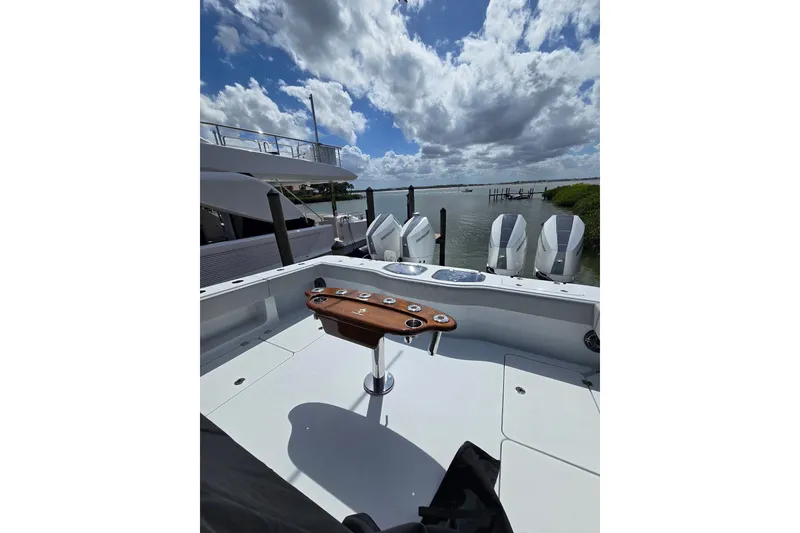 Slide: The Image of Freeman 47 boat, 2025 model, docked with multiple outboard engines under a cloudy sky. - 12