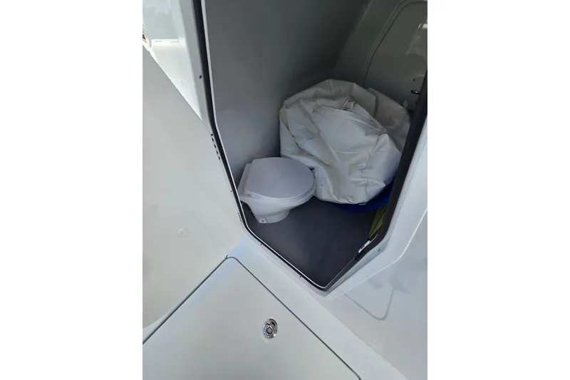 Slide: The Image of Compact bathroom area in a 2025 Freeman 47 boat, featuring a toilet and storage space. - 15