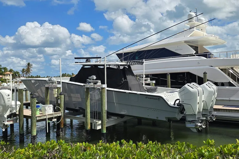 Slide: The Image of Freeman 47 boat from 2025 docked with multiple outboard engines, under a blue sky. - 2
