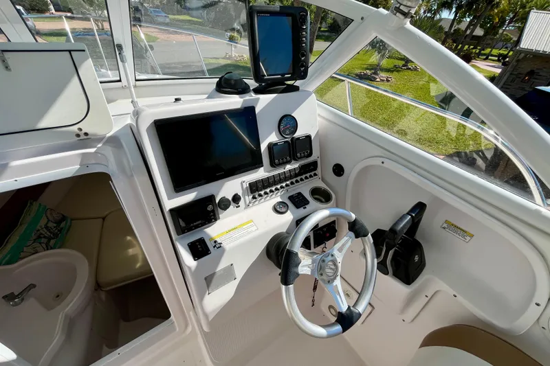 Slide: The Image of 2018 Pro-Line 26 Express boat cockpit with steering wheel and navigation equipment. - 15
