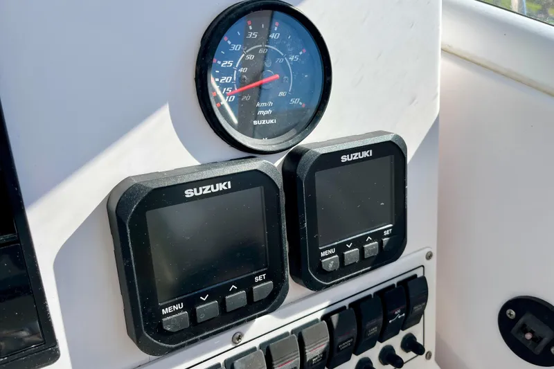 Slide: The Image of Dashboard of 2018 Pro-Line 26 Express boat with Suzuki gauges and controls. - 18