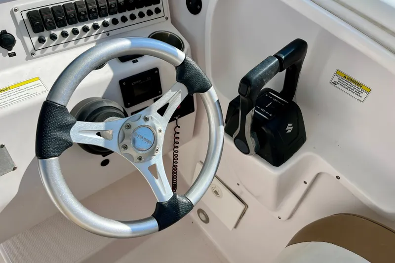 Slide: The Image of Steering wheel and controls of 2018 Pro-Line 26 Express boat cockpit. - 22