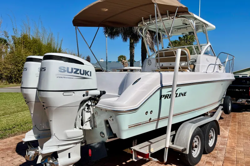 Slide: The Image of 2018 Pro-Line 26 Express boat with twin Suzuki engines on a trailer. - 3