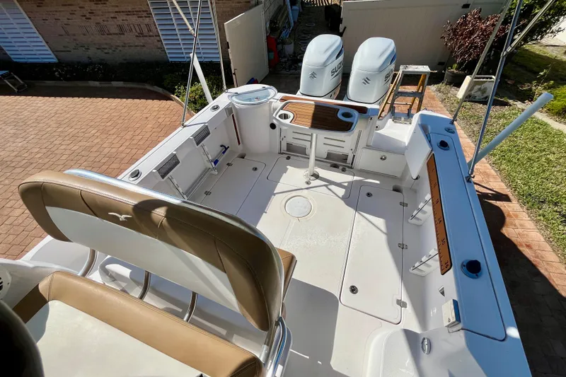 Slide: The Image of 2018 Pro-Line 26 Express boat deck with seating, dual engines, and fishing rod holders. - 33