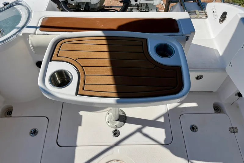 Slide: The Image of Cockpit of 2018 Pro-Line 26 Express boat with wooden table and cup holders. - 34