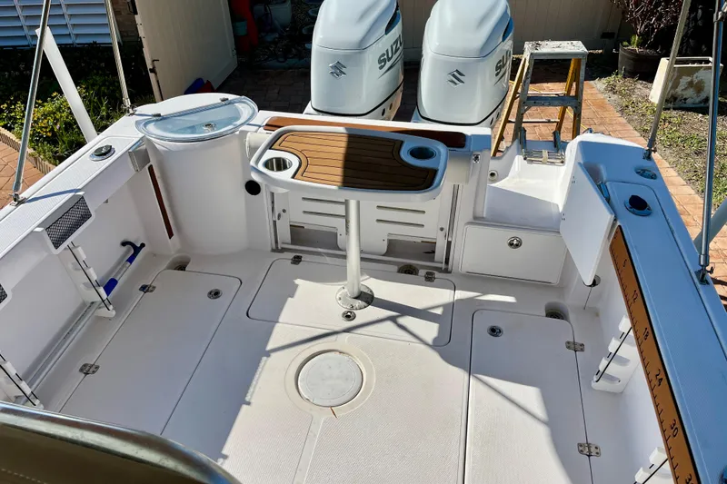 Slide: The Image of 2018 Pro-Line 26 Express boat deck with dual Suzuki engines and fishing amenities. - 35