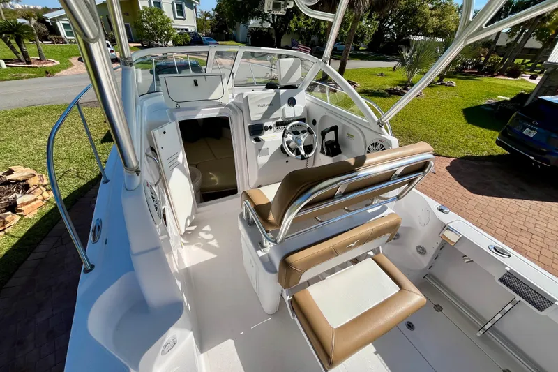Slide: The Image of 2018 Pro-Line 26 Express boat interior with helm, seating, and open cabin door. - 38