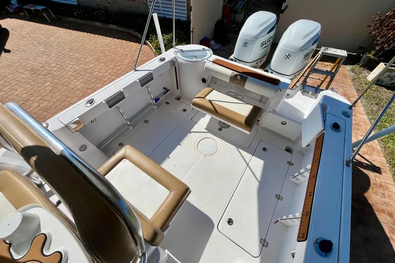 Slide: The Image of 2018 Pro-Line 26 Express boat interior with seating and dual Suzuki outboard motors. - 39