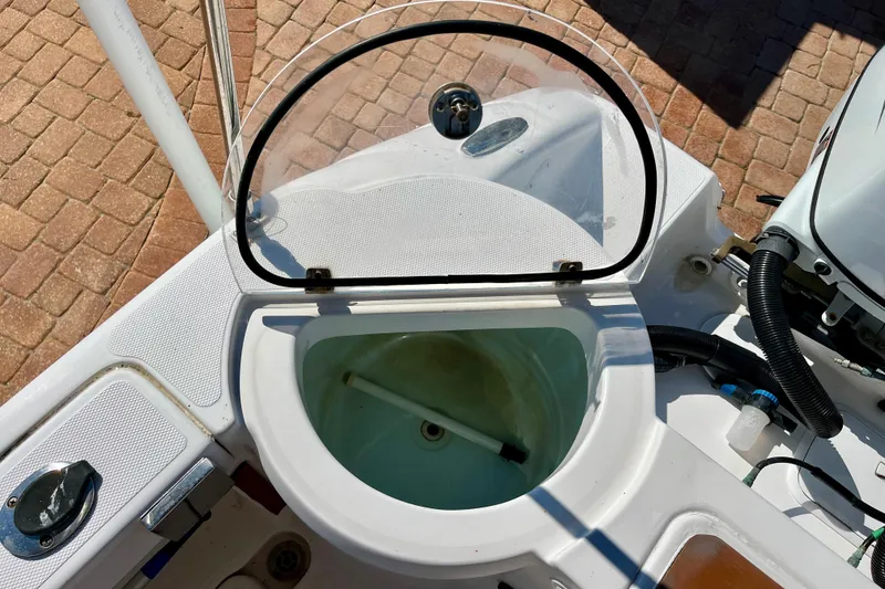 Slide: The Image of 2018 Pro-Line 26 Express boat livewell with open lid, showcasing interior and surrounding deck. - 42