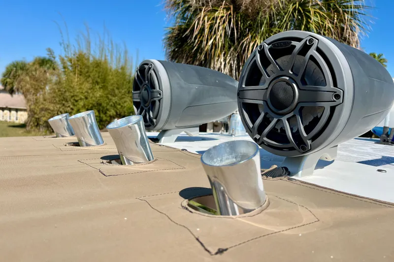 Slide: The Image of 2018 Pro-Line 26 Express boat speakers and rod holders under clear blue sky. - 47
