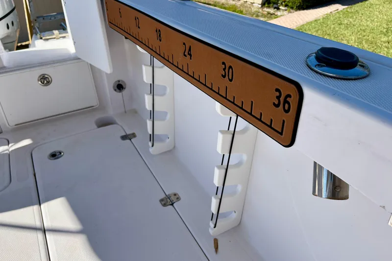 Slide: The Image of Interior view of 2018 Pro-Line 26 Express boat with measuring ruler and storage compartments. - 58