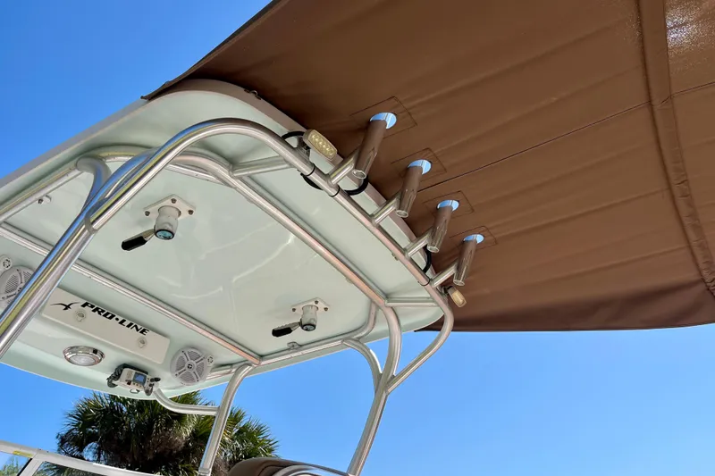 Slide: The Image of 2018 Pro-Line 26 Express boat canopy and rod holders under clear blue sky. - 59