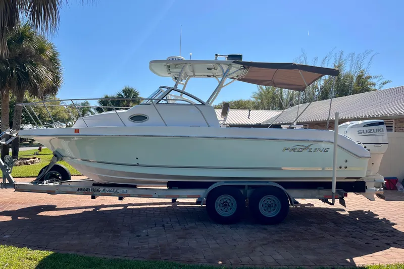 Slide: The Image of 2018 Pro-Line 26 Express boat on trailer, parked outdoors under clear sky. - 6